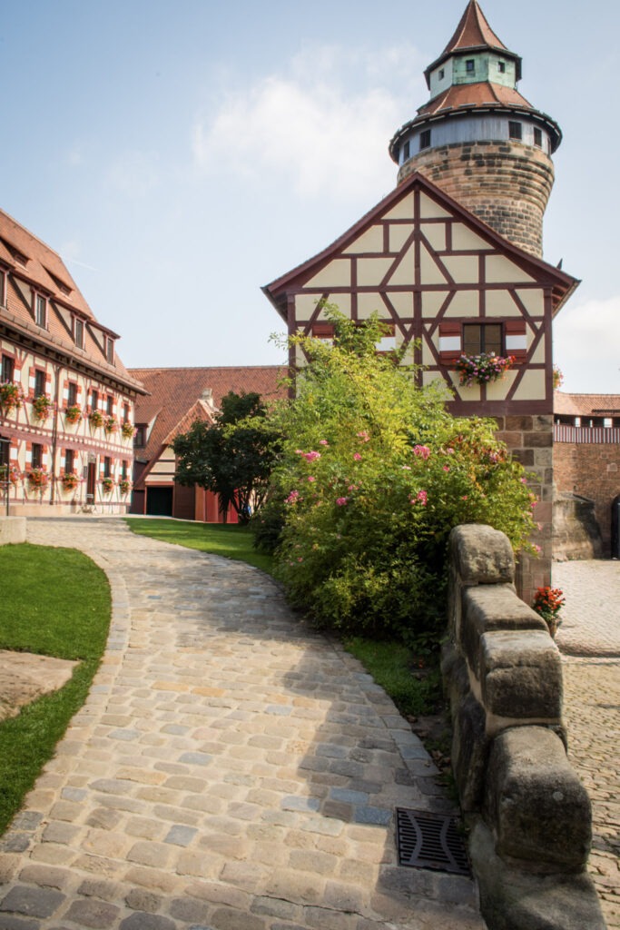 tower and timberframed building with cobblestone path in nuremberg