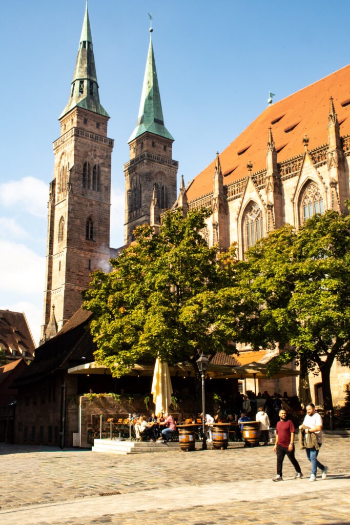 church sitting on a square with a restaurant specializing in Nuremberg sausages