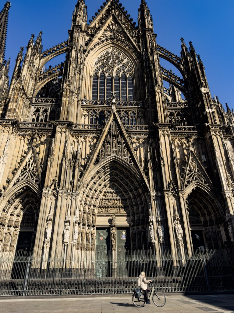 exterior of the cathedral in cologne with a person on a bike