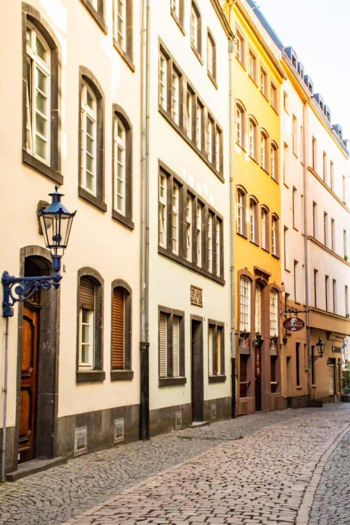 a curved street with cobblestone road is cologne germany