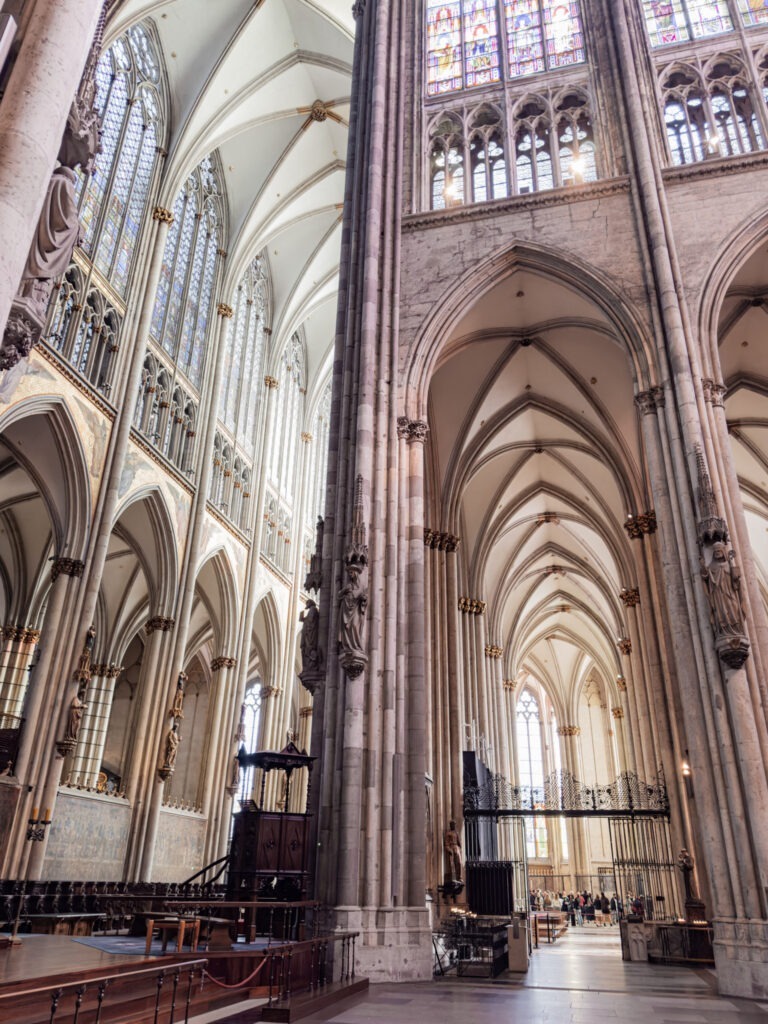 inside cologne cathedral with soaring ceilings and stained glass
