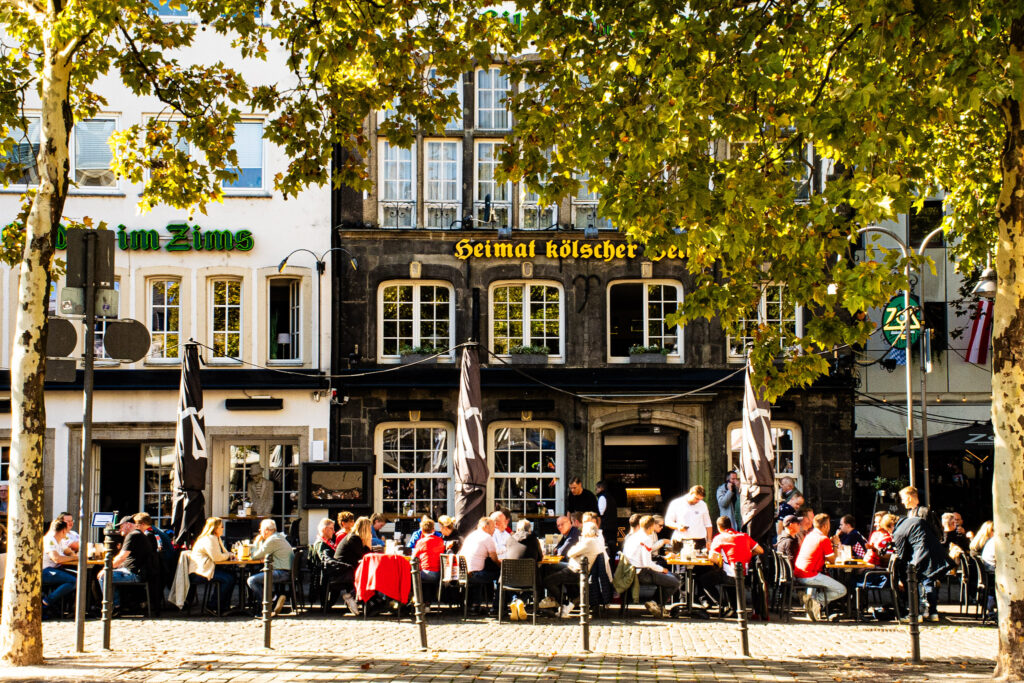 What to See + Do in Cologne in One Day 8 restaurant under the tree canopy drinking beer in cologne for a day