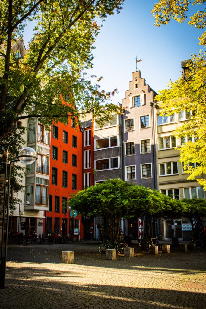 sunlight on square with tall brightly coloured buildings in cologne