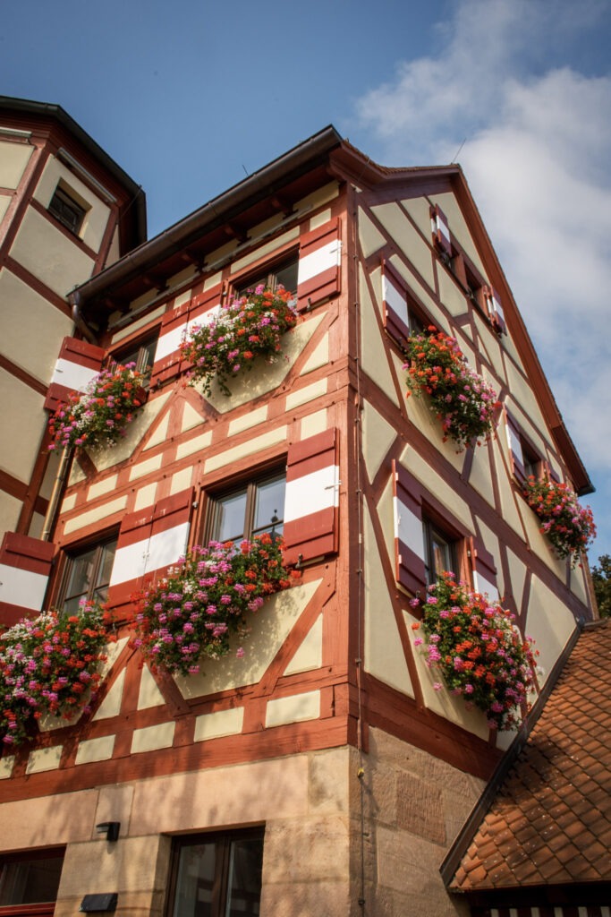 red and white timberframed building with flower boxes in nuremberg