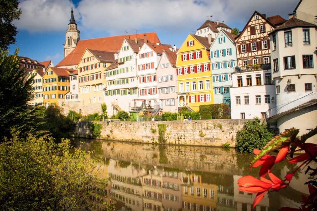 river with colourful tall medieval buildings along the riverbank reflected in the water makes Tubingen worth visiting