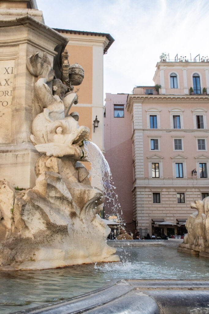 fountain with pink building while spending 2 days in Rome