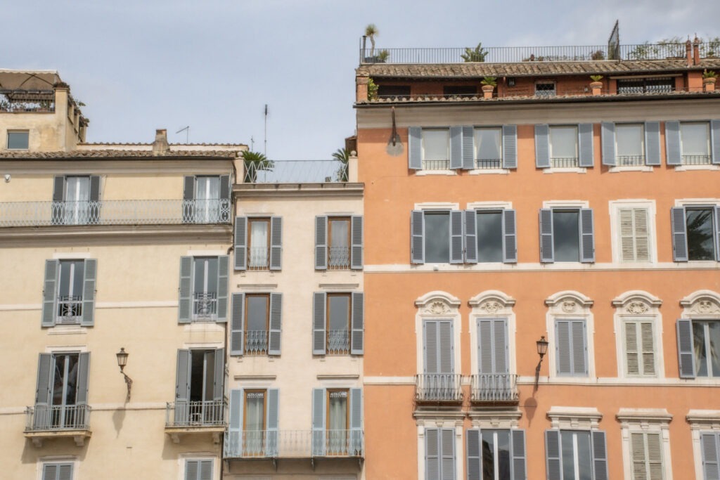 vacation apartments in rome in pastel orange, yellow and cream with gray shutters