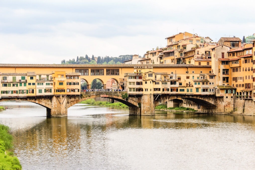 view of bridge with yellow buildings and archways over the arno river while spending 3 days in florence