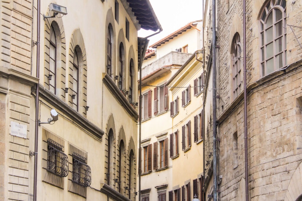 piazza with curved buildings with brown shutters in Florence Italy