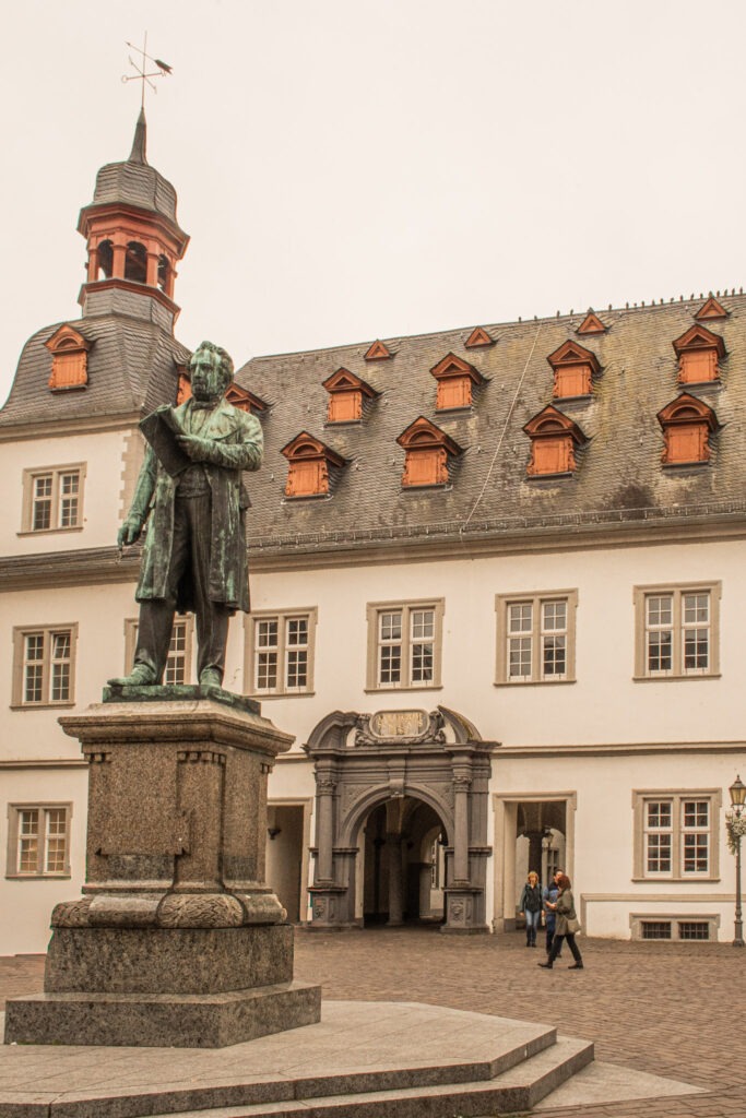 statue with stately palace behind in white while visiting koblenz