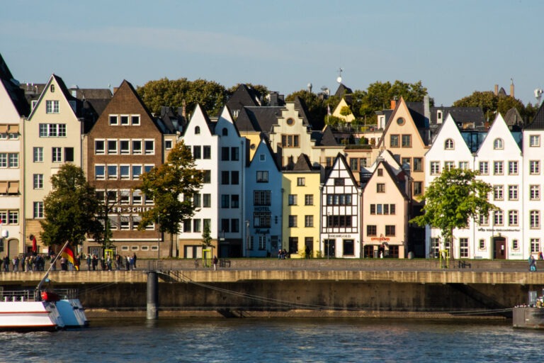 rows of colourful buildings along the riverside of the Rhine River in one of the cities called Cologne