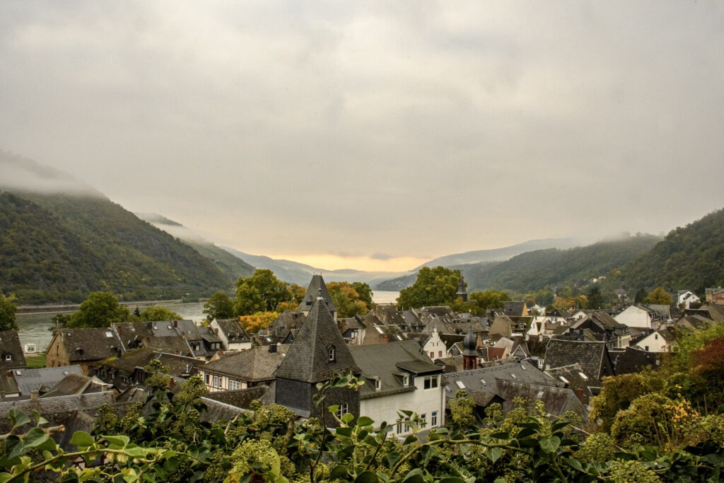 view of the rooftops in bacharach with rhine river and mountains