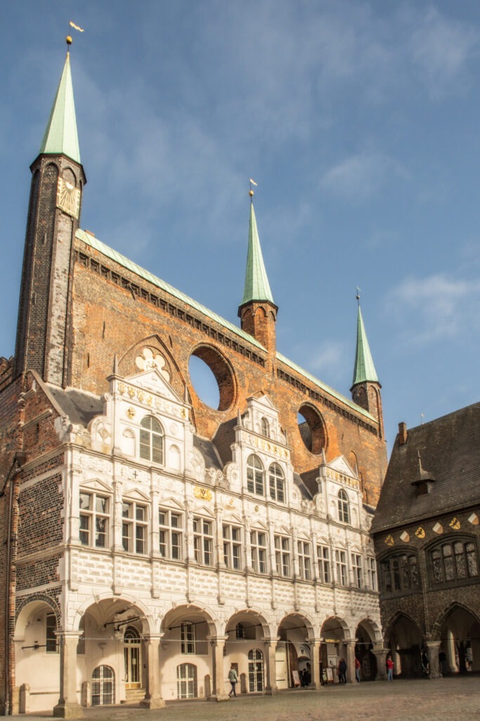 visiting lubeck and the main market square with its city hall in white facade with tall red brick towers behind it