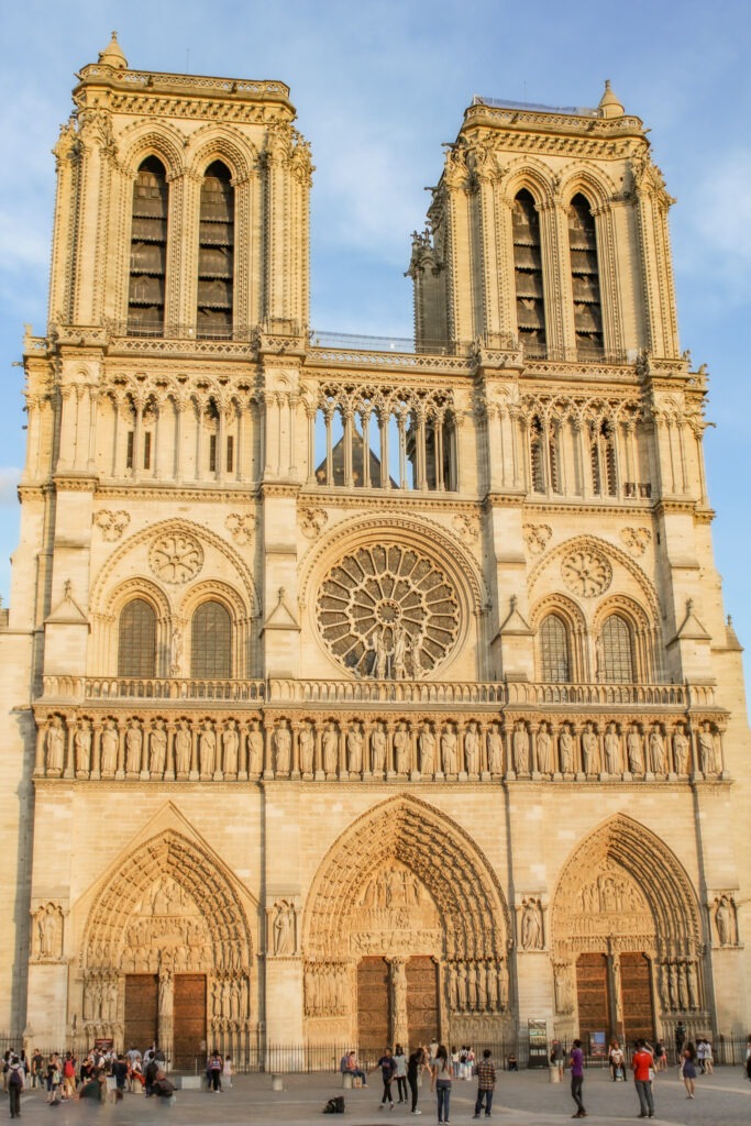 Detailed façade of Notre Dame Cathedral rises above the city with intricate stonework, rose window, and twin bell towers. Visiting this historic landmark is a key experience for many travelers planning 4 days in Paris.