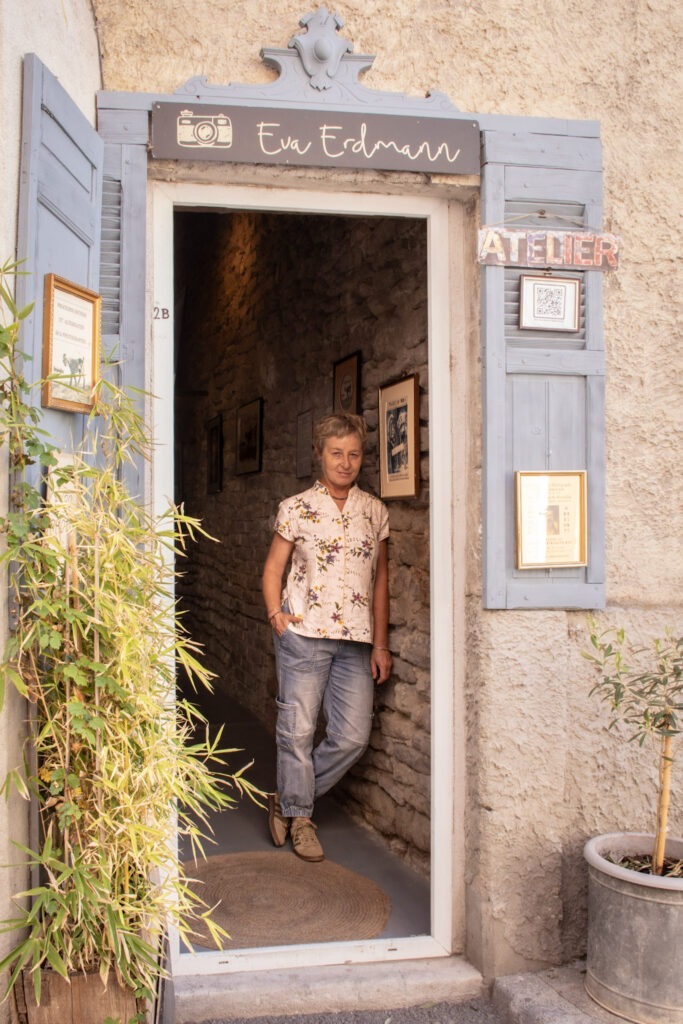 Open doorway to Eva Erdmann's photography studio in L’Isle-sur-la-Sorgue, with Eva Erdmann standing at the entrance.