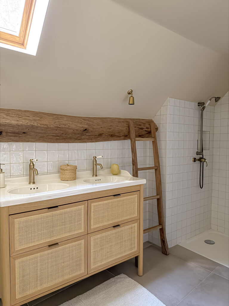 Ensuite bathroom at Moulin de Rochopt with wood vanity, brass fittings and exposed timber