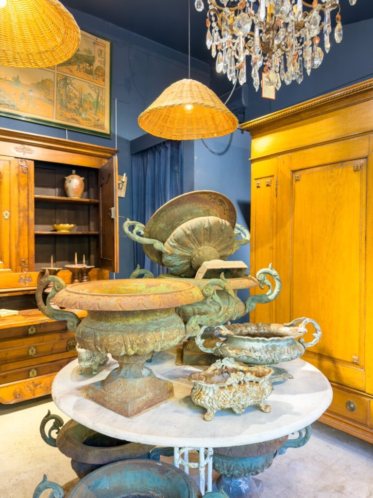 L'Isle-sur-la-Sorgue antique market with marble table with weathered antique urns and chandelier