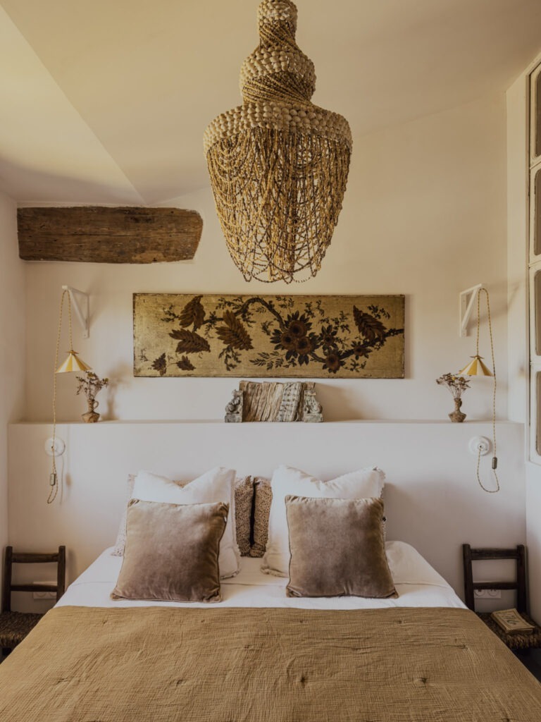 Bedroom at Le 40 by Maisons Clotilde in L’Isle-sur-la-Sorgue, featuring neutral linens, floral artwork and a woven pendant light.