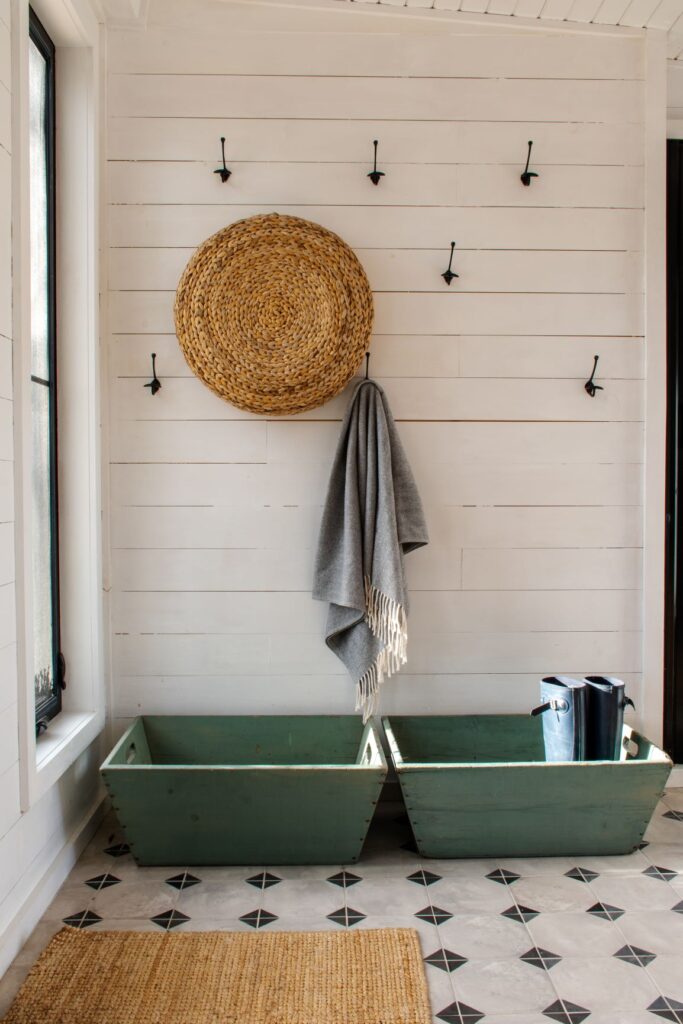 interior of a place to stay in prince edward county showing a wall with black hooks, woven basket, and scarf at doorway