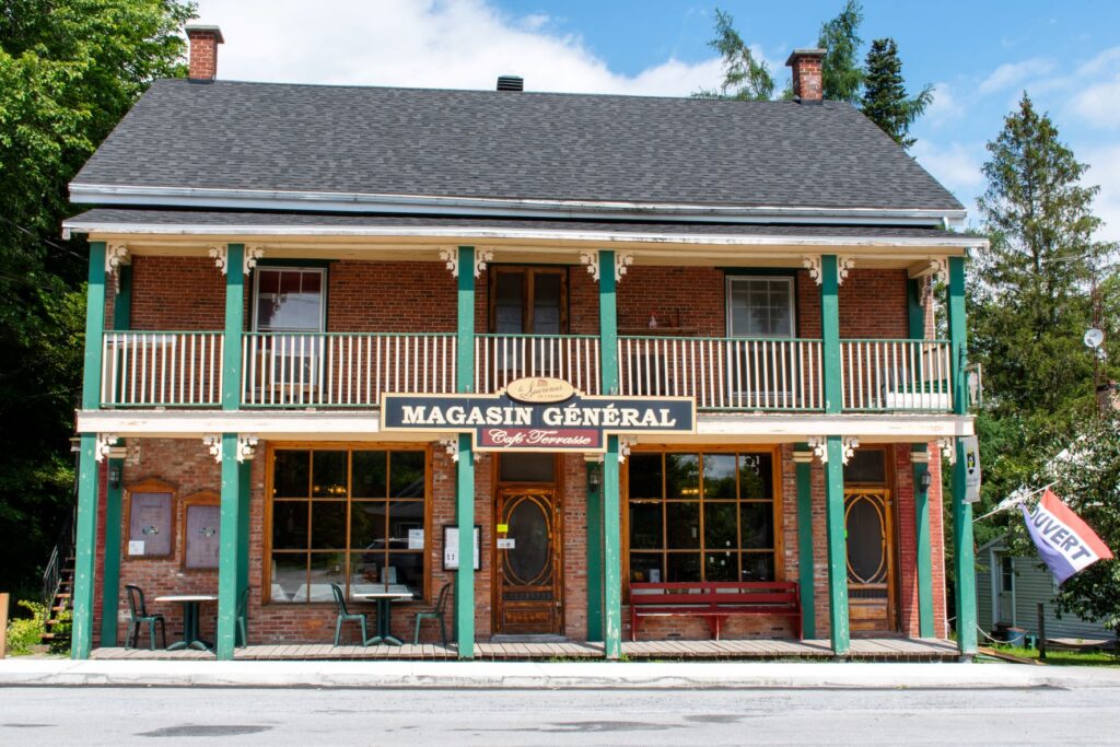 general store in eastern townships with front porch with green pillars in quebec village