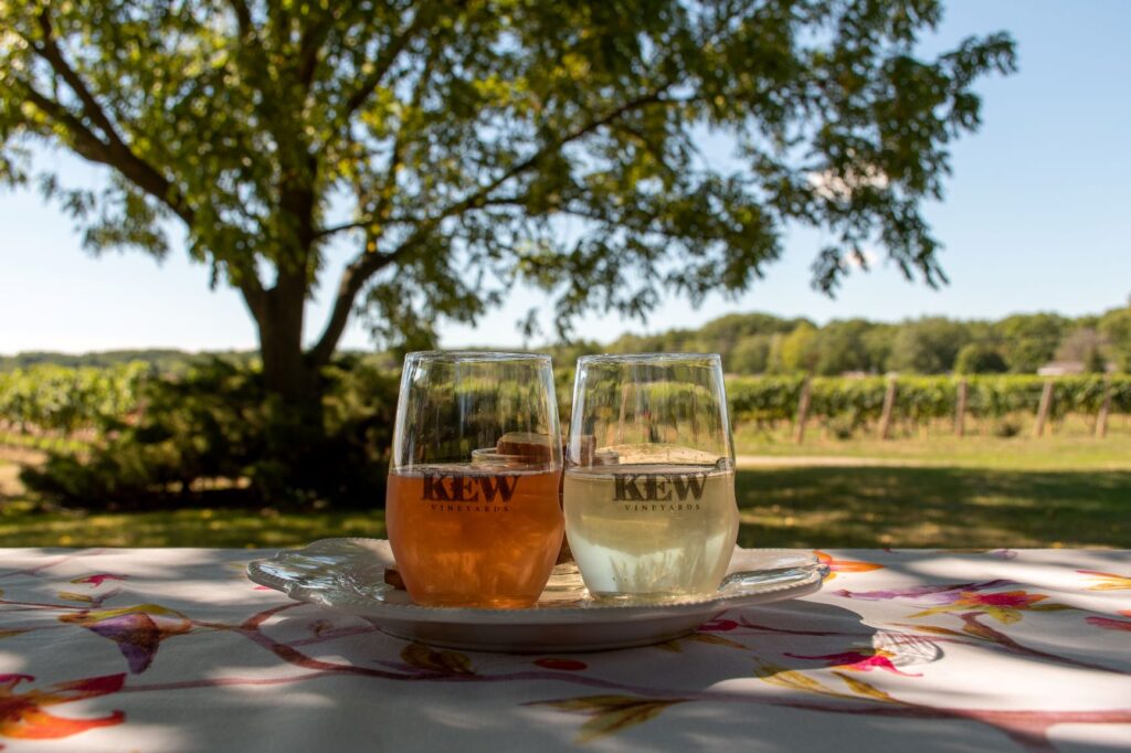 2 glasses of wine on picnic table in front of winery in Niagara Region beamsville winery