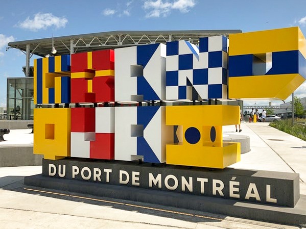 welcome sign for old montreal in yellow, white and blue