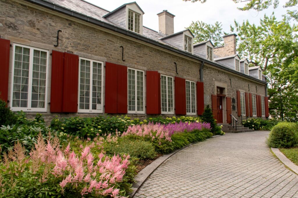 historic buiding with flowers and red shutters in old montreal things to do