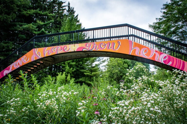 bridge says 'love & hope lives here' with gardens