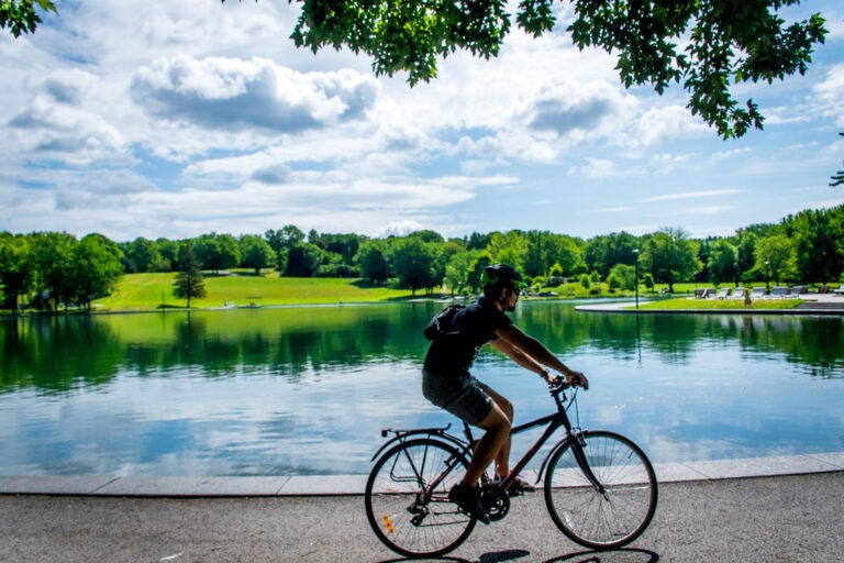 man on bike in front of lake in mont royal park in Montreal