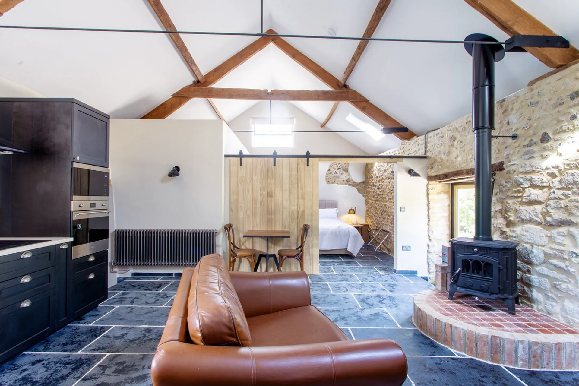 vaulted ceiling, wood stove and leather sofa