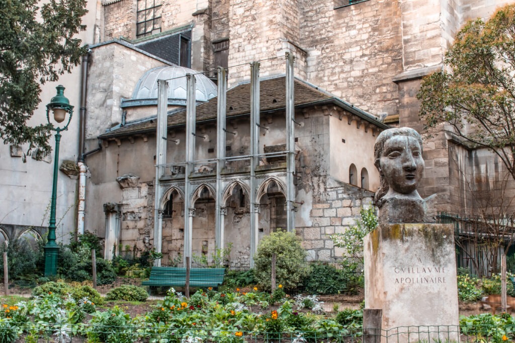 hidden gardens paris behind church iwith statue 