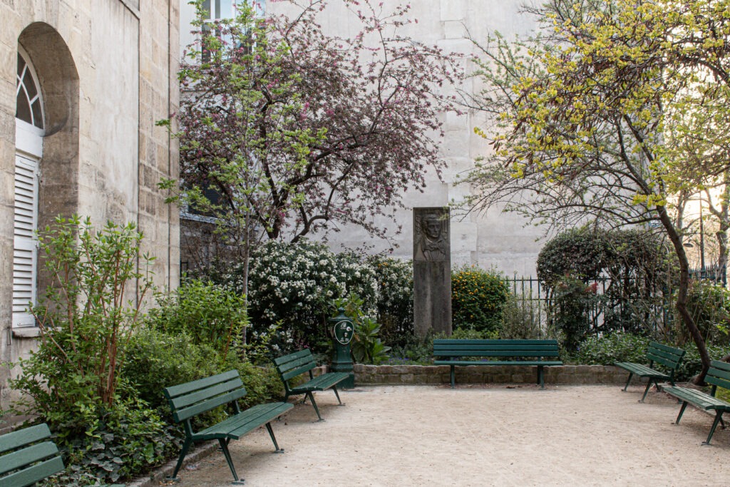 hidden park in paris with statue and green park benches