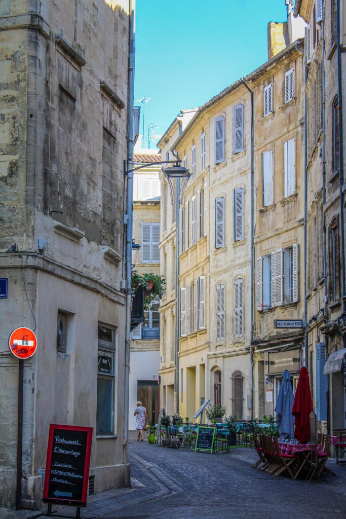 a cobbled street with tall buildings on a visit to avignon