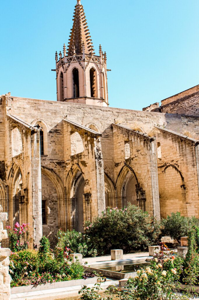 a church with large buttresses and garden is one of the avignon attractions