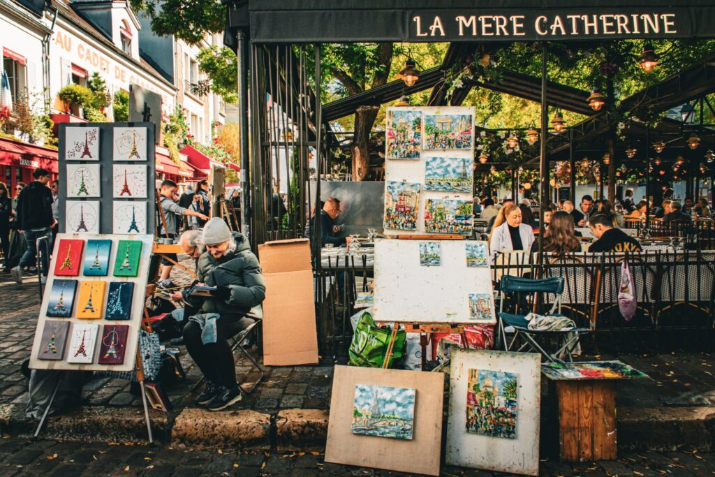 artwork on street with artist in one of Paris main streets in Montmartre where artists gather