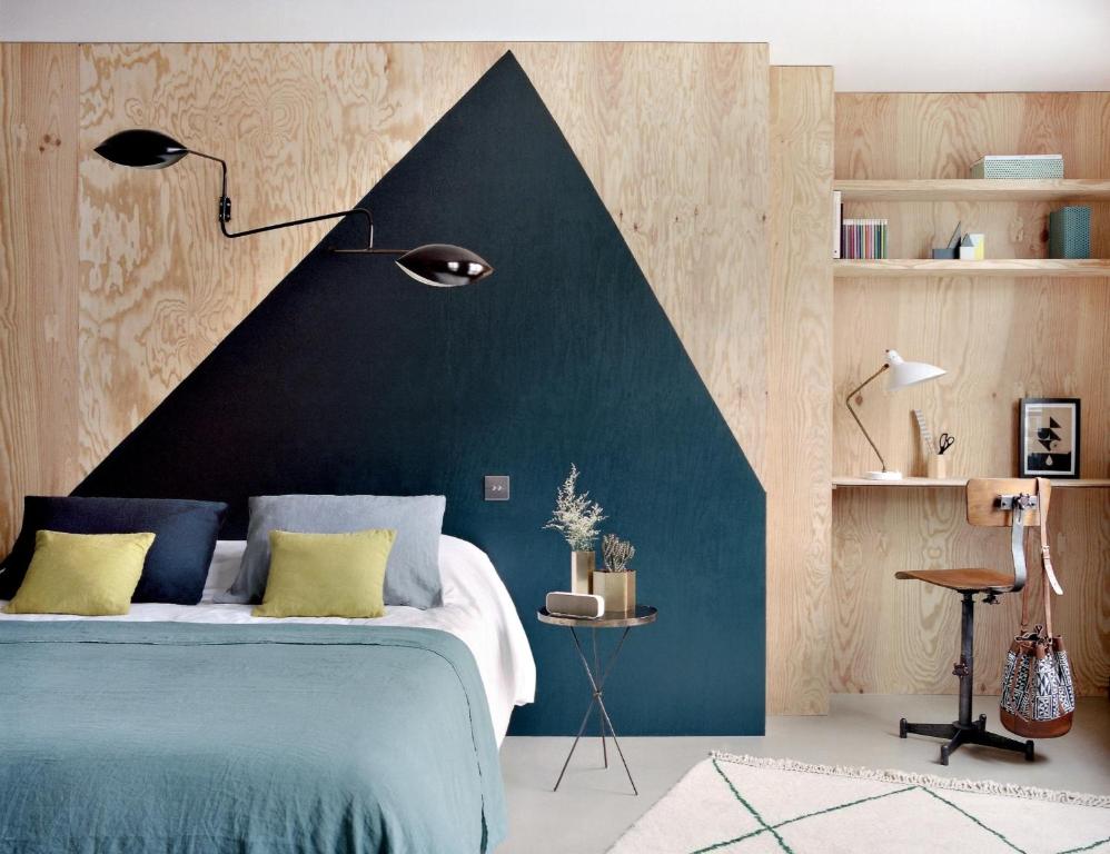 bed with wood wall and shelving in Paris boutique hotel