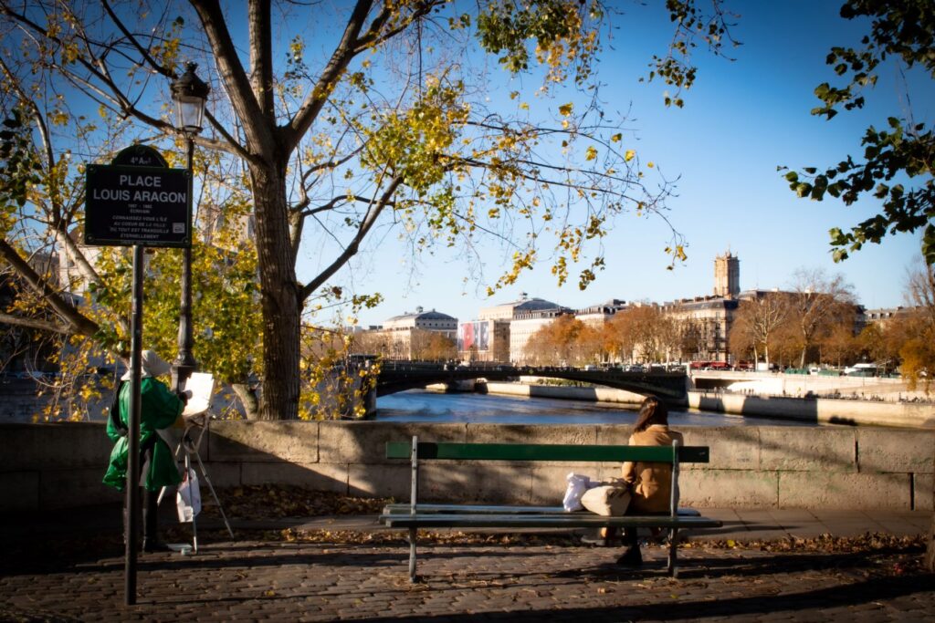 bench with woman overlooking water in ile saint louis