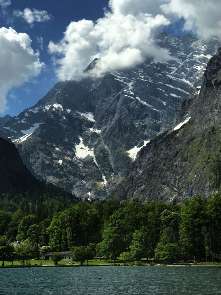 green lake of konigsee with dense forest and alps while visiting berchtesgaden national park on a day trip