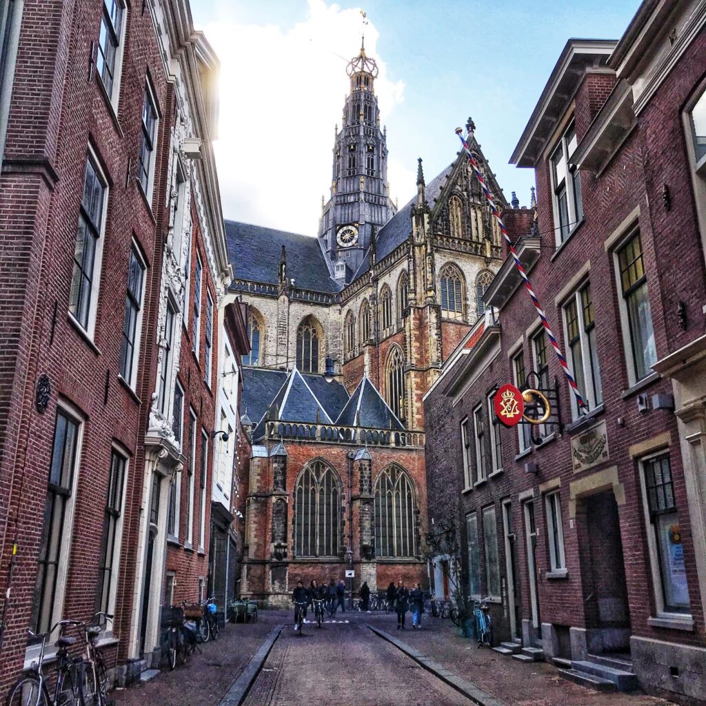 church and cobblestone laneway as you look to the church spire, as you figure out how to get to Haarlem from amsterdam