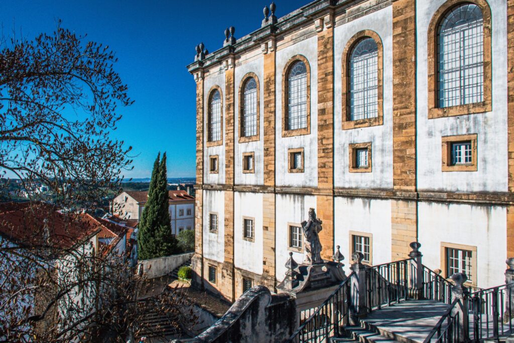 stone building with stairs and view of river while on a Coimbra day trip from porto