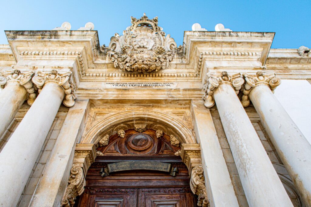 pillars, door and crest for a library a must see in one day in coimbra