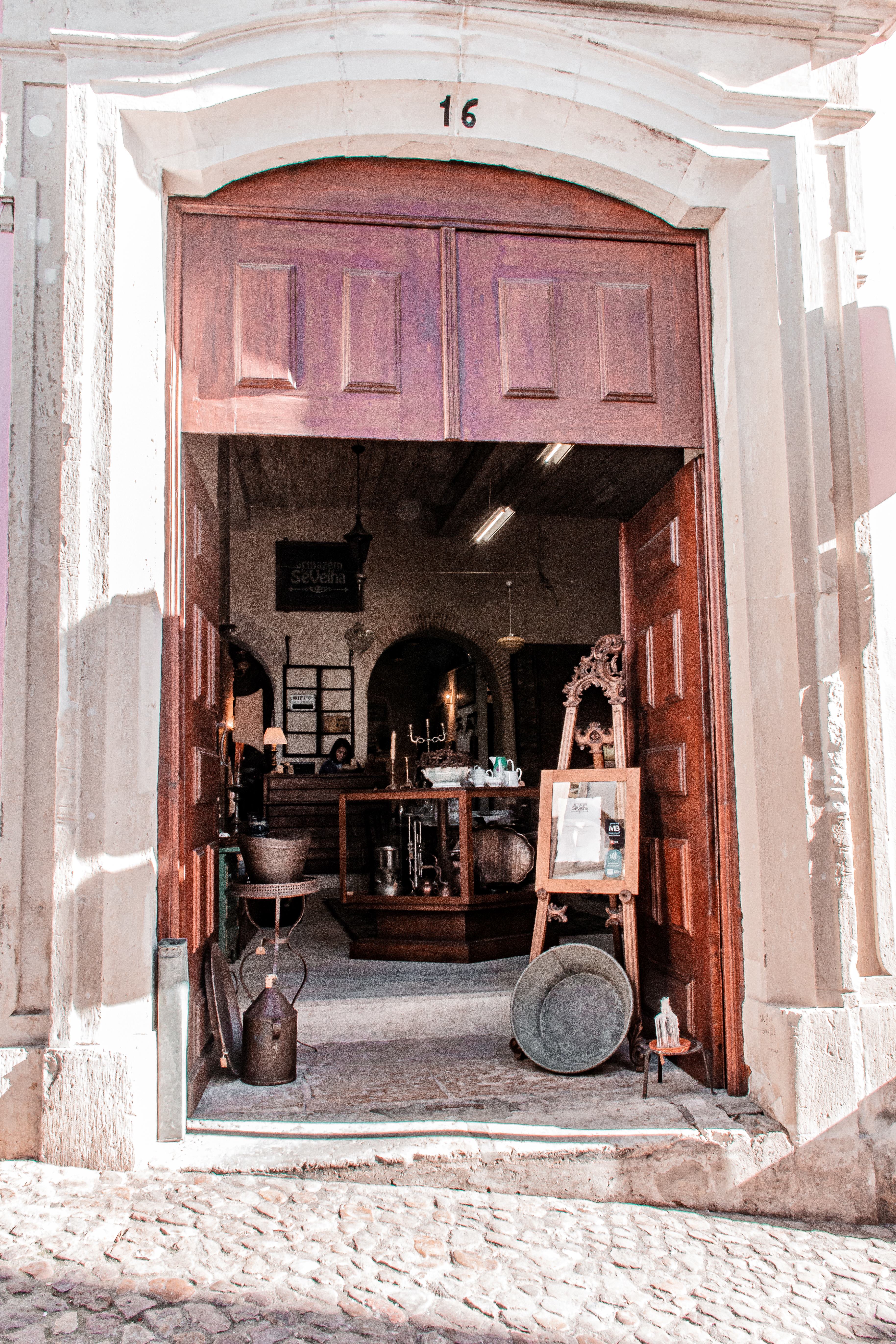 stone street with shop with objects in doorway in coimbra from lisbon day trip