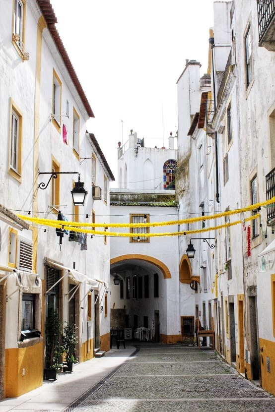 laneway with white and yellow buildings in evora portugal