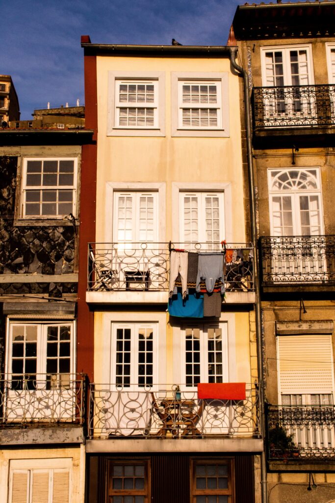 one of the reasons to visit porto is for its tall colourful buildings with laundry hanging from its iron terraces