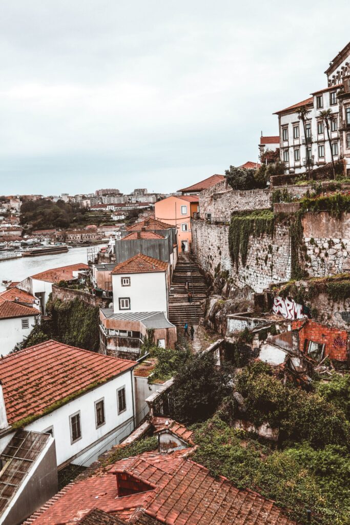 buildings on side of cliff with red roof tops and view of river from Porto