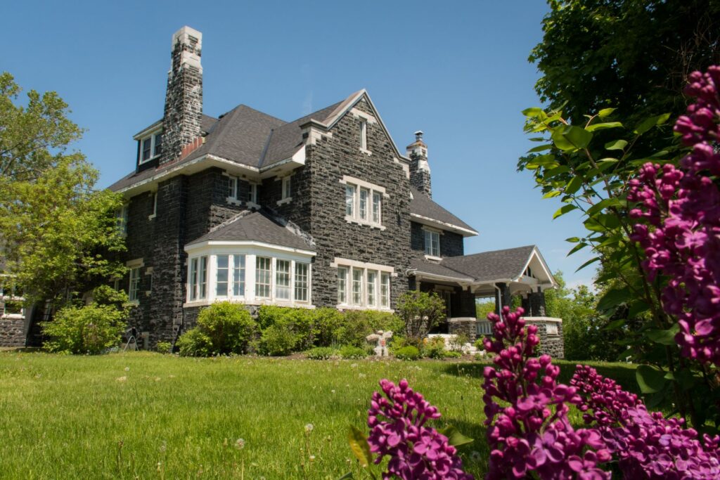 gray stone house with lawn while at long lake sudbury ontario