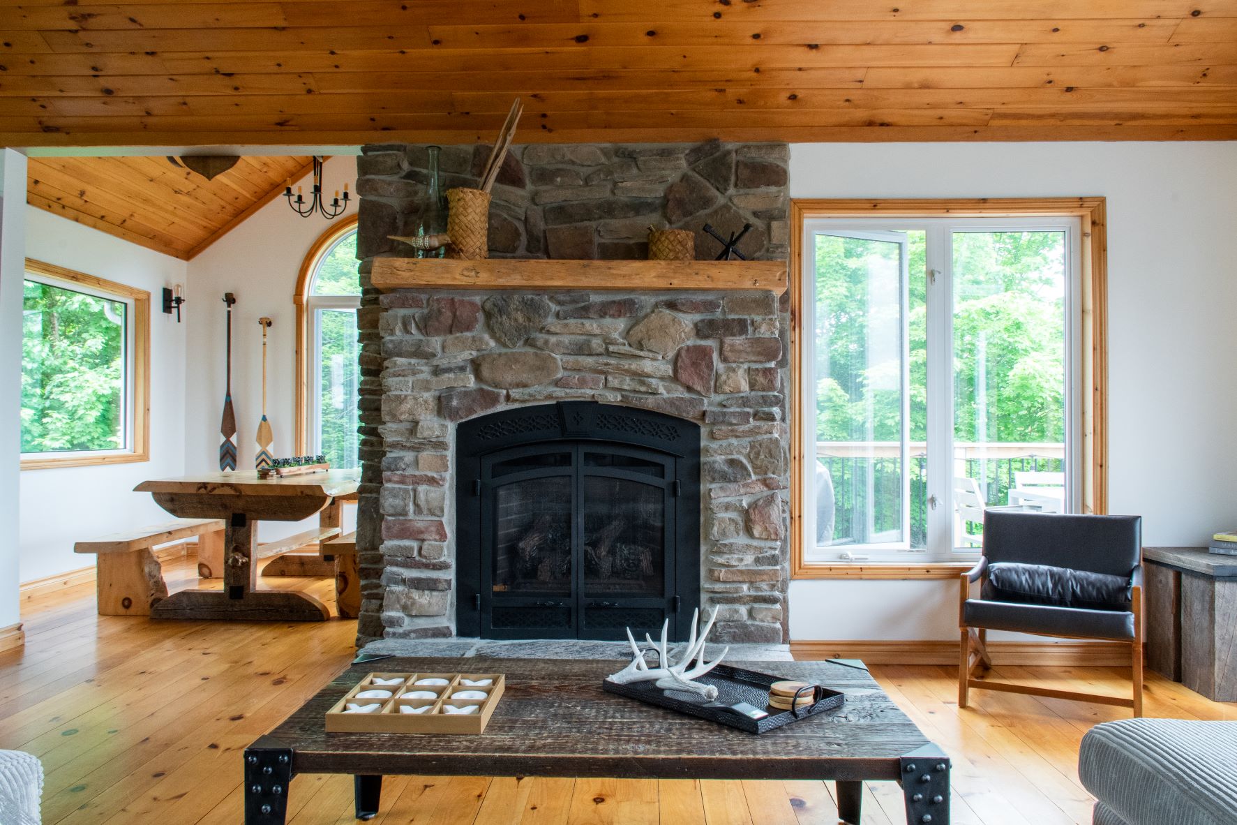 stone fireplace, wood panel ceiling and floor