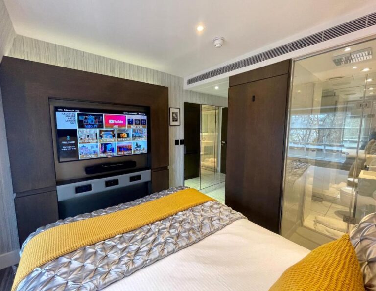 bed with tv and glass wall to window