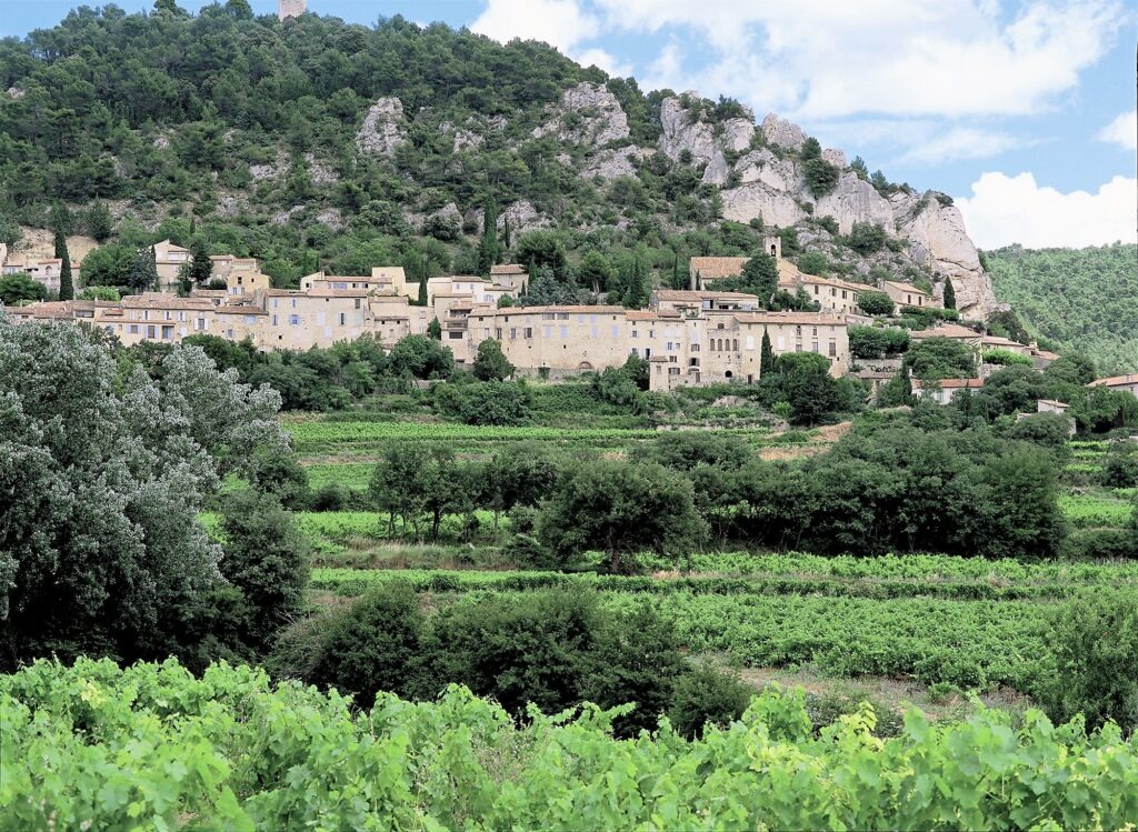grass in valley with stone village in front of hill is one of the beautiful villages in provence